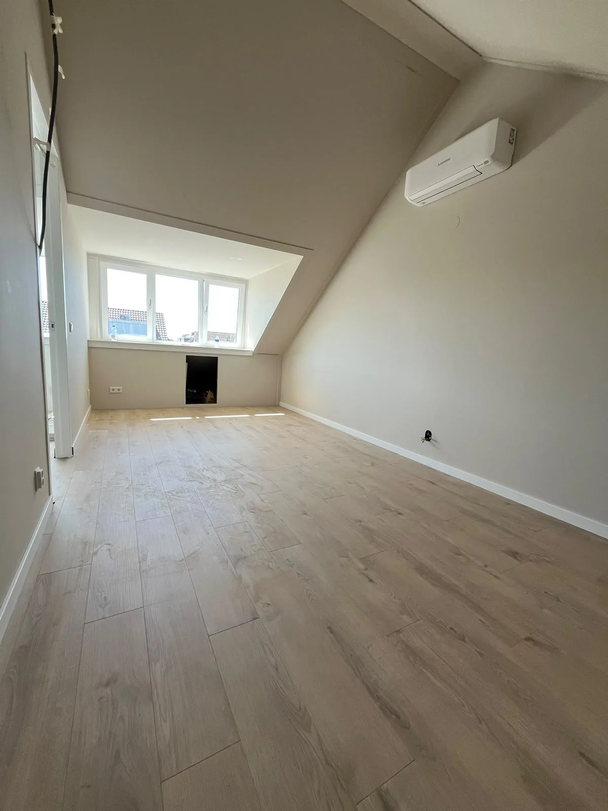 Zolderkamer met lichte vloer en airco