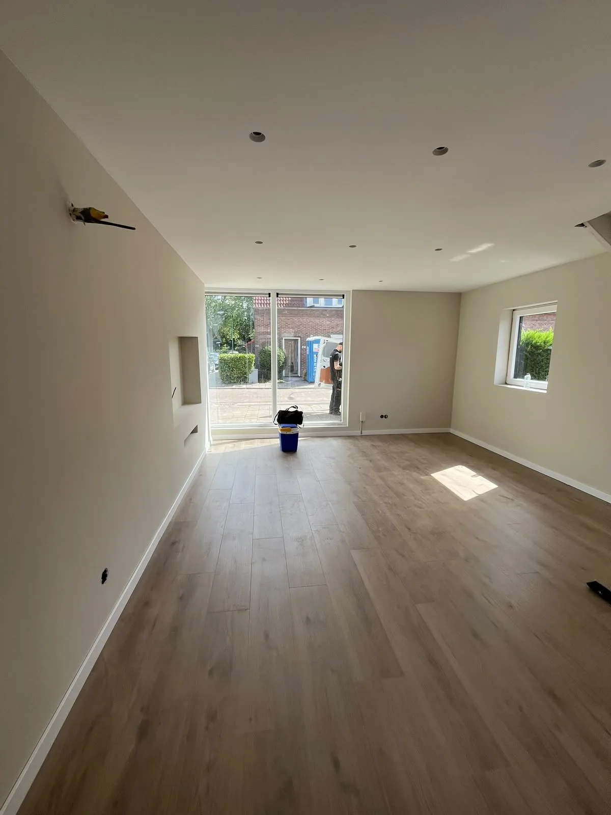 Nieuwbouw woonkamer met lichte vloer en grote ramen