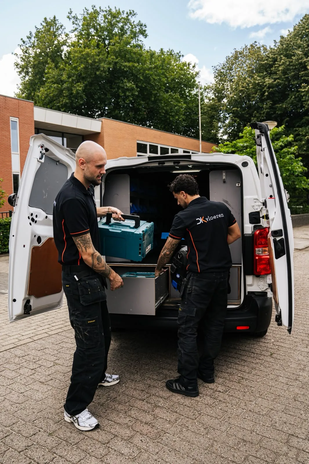 Daan en Thomas laden gereedschap uit de bedrijfsbus